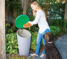 mom putting in kitchen waste inside a pet poo worm farm